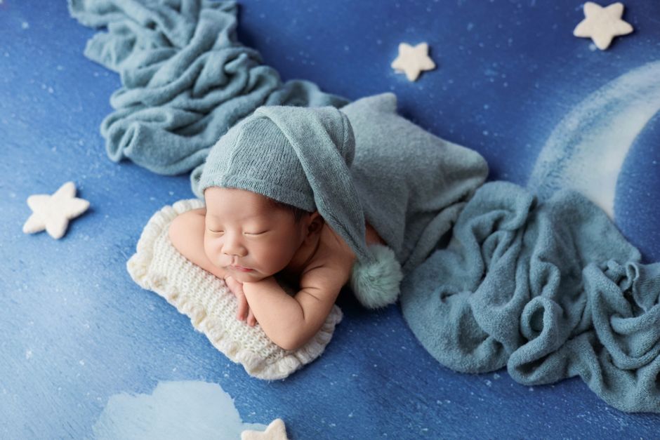 Cute newborn baby sleeping in a dreamy setup with stars and moon in Ho Chi Minh City studio.