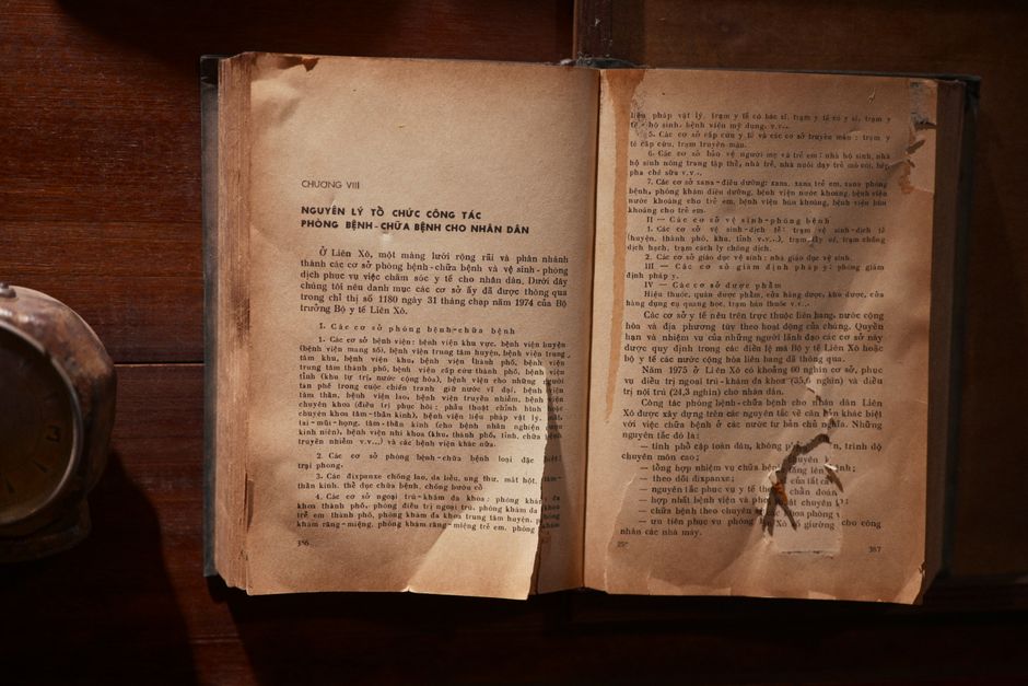 A vintage open book with text in Vietnamese on a wooden table, showcasing old literature.